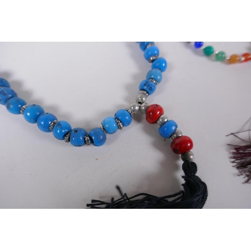 663 - A string of blue and red glass mala beads, a string of tiger's eye mala beads, a string of dried bea... 