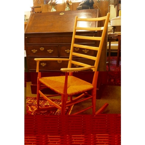 1063 - A beech wood ladder back rocking chair with rush seat