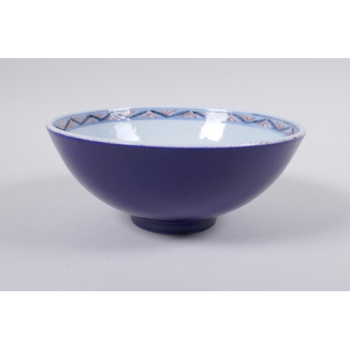 100 - A Chinese porcelain bowl with blue, white and red dragon decoration to the interior and a blue glaze... 