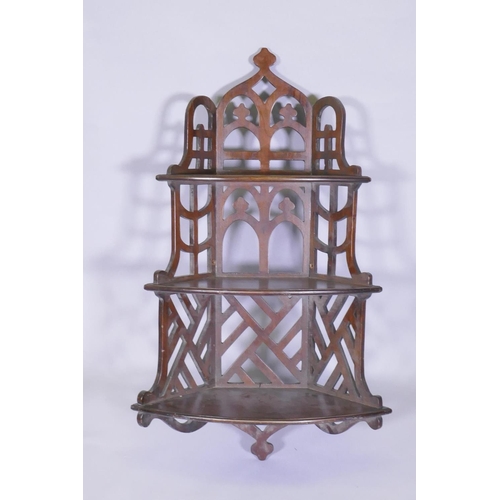 1002 - A mahogany Gothic style open fretwork hanging corner shelf, with pierced back and sides and three bo... 