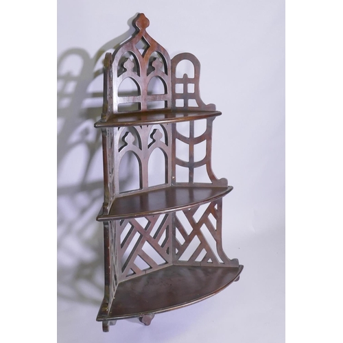 1002 - A mahogany Gothic style open fretwork hanging corner shelf, with pierced back and sides and three bo... 