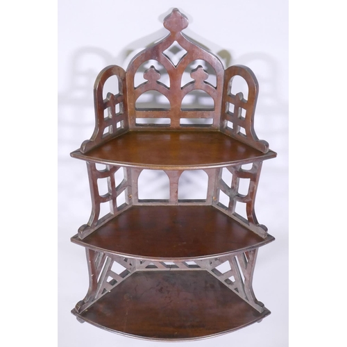 1002 - A mahogany Gothic style open fretwork hanging corner shelf, with pierced back and sides and three bo... 