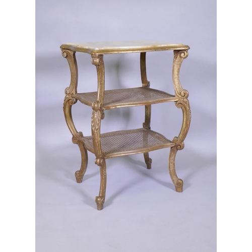 1004 - A C19th Italian giltwood three tier serpentine shaped etagere, with inset marble top and caned tiers... 