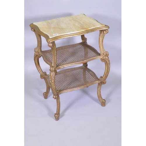 1004 - A C19th Italian giltwood three tier serpentine shaped etagere, with inset marble top and caned tiers... 