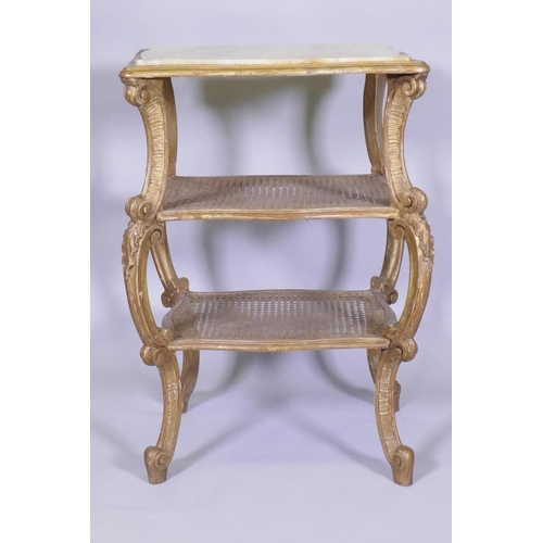 1004 - A C19th Italian giltwood three tier serpentine shaped etagere, with inset marble top and caned tiers... 