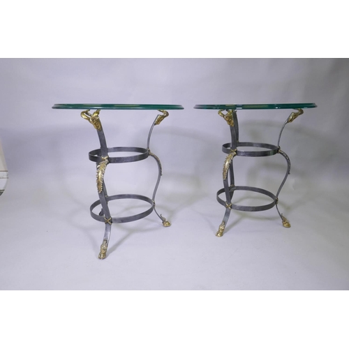 1007 - A pair of Maison Jansen style wrought steel occasional tables with brass mounts, goat's mask decorat... 