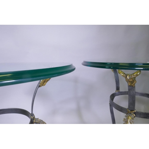 1007 - A pair of Maison Jansen style wrought steel occasional tables with brass mounts, goat's mask decorat... 