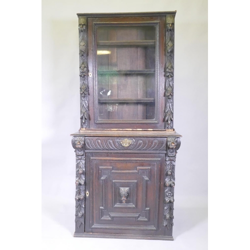 1011 - A C19th French carved oak bookcase with lion mask decoration and a glazed upper section, 84 x 48cm, ... 