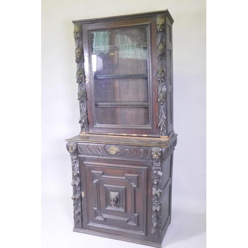 1011 - A C19th French carved oak bookcase with lion mask decoration and a glazed upper section, 84 x 48cm, ... 