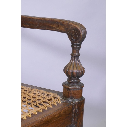 1021 - A C19th Anglo Indian style/Zanzibar hardwood elbow chair, with caned seat and back, reeded arms, rai... 