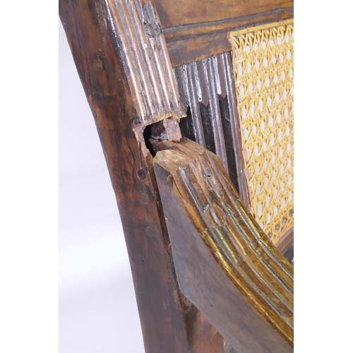 1021 - A C19th Anglo Indian style/Zanzibar hardwood elbow chair, with caned seat and back, reeded arms, rai... 