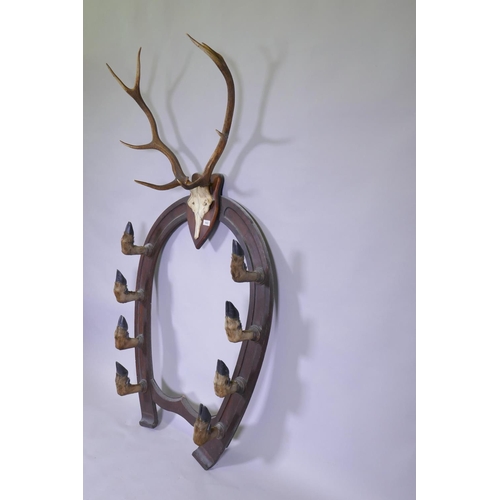 1022 - A Victorian oak gun rack in the form of horse shoe with deer's hoof hooks and antler crest, 84cm wid... 