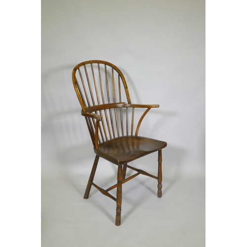 1031 - A C19th elm Windsor stick back arm chair, with historic restorations