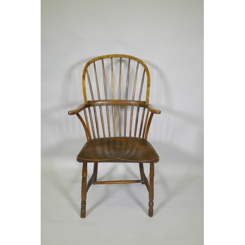 1031 - A C19th elm Windsor stick back arm chair, with historic restorations