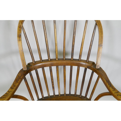 1031 - A C19th elm Windsor stick back arm chair, with historic restorations