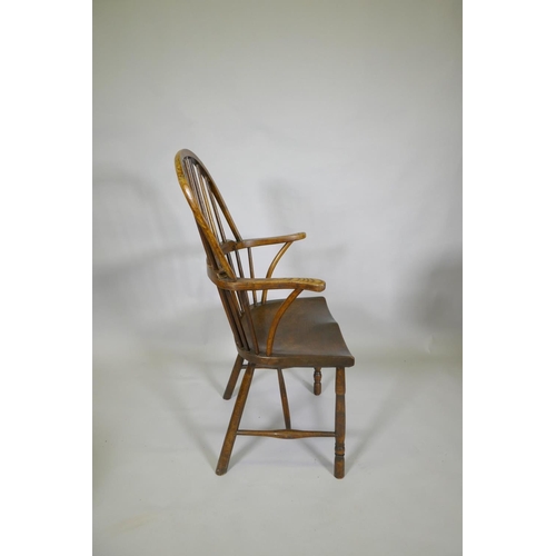 1031 - A C19th elm Windsor stick back arm chair, with historic restorations