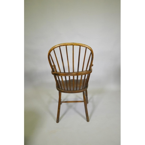 1031 - A C19th elm Windsor stick back arm chair, with historic restorations