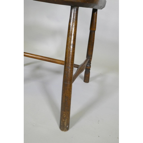 1031 - A C19th elm Windsor stick back arm chair, with historic restorations