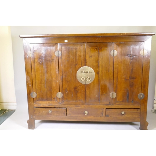 1048 - A Chinese hardwood cabinet with brass mounts and folding doors, raised on shaped supports, 186 x 64 ... 