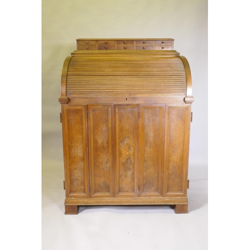 1050 - A late C19th/early C20th walnut tobacconist's shop cabinet, the roll top opening to reveal drawers o... 