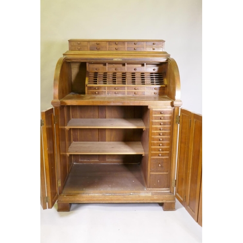 1050 - A late C19th/early C20th walnut tobacconist's shop cabinet, the roll top opening to reveal drawers o... 