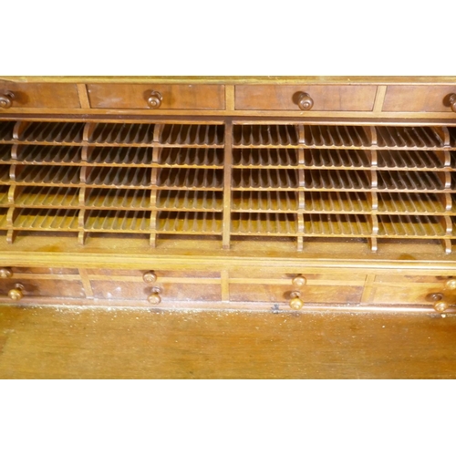 1050 - A late C19th/early C20th walnut tobacconist's shop cabinet, the roll top opening to reveal drawers o... 