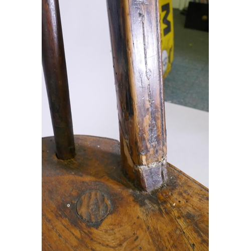 1061 - An early C19th elm wheel back dining chair with crinoline stretcher, AF, and an C18/C19th French oak... 