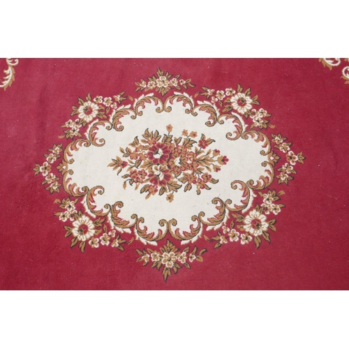 1066 - A large oriental red ground carpet with a cream floral medallion and borders, 240 x 330cm