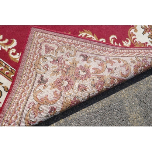 1066 - A large oriental red ground carpet with a cream floral medallion and borders, 240 x 330cm