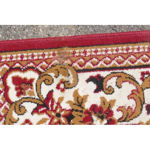 1066 - A large oriental red ground carpet with a cream floral medallion and borders, 240 x 330cm