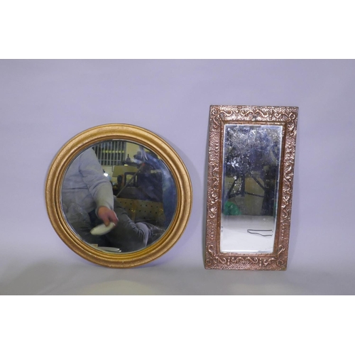 1069 - An antique Arts & Crafts copper mirror with repousse decoration, and a circular gilt wall mirror... 