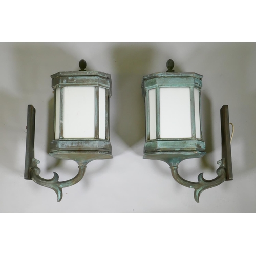 1075 - A large pair of early C20th bronze wall lanterns, well patinated and wired for electricity, 75cm hig... 