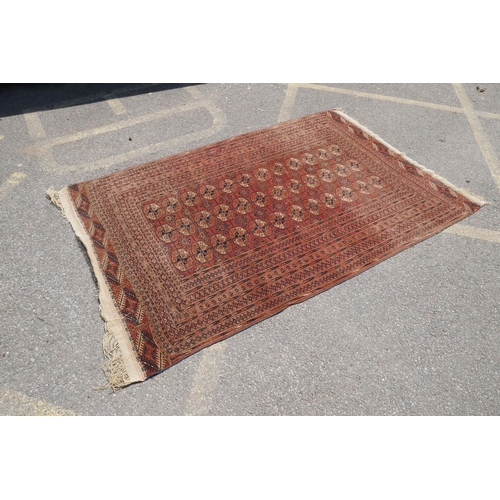 1083 - An antique wool terracotta ground bokhara carpet, 148 x 226cm, AF