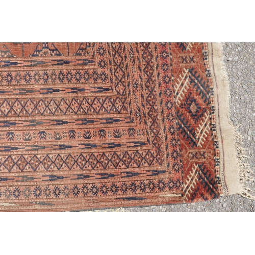 1083 - An antique wool terracotta ground bokhara carpet, 148 x 226cm, AF