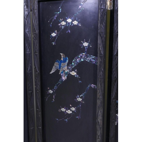 112 - An antique Japanese four fold black lacquer screen with inlaid mother of pearl and abalone decoratio... 