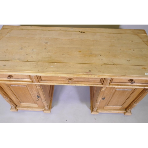 1127 - A C19th continental pine kneehole desk, with three drawers over two cupboards fitted with shelves, 1... 