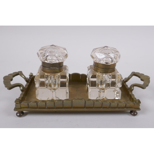 114 - An antique brass and glass twin inkwell desk stand, 21 x 9cm