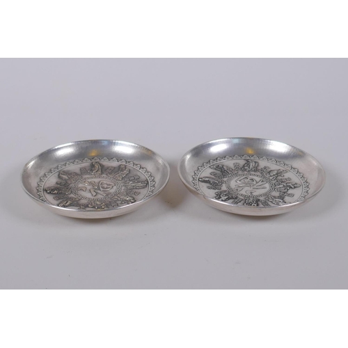 116 - A pair of Chinese white metal trinket dishes with raised decoration of the eight immortals, mark to ... 