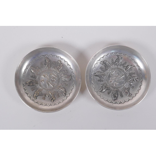 116 - A pair of Chinese white metal trinket dishes with raised decoration of the eight immortals, mark to ... 