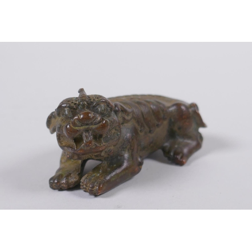 118 - A Japanese style bronze okimono in the form of a temple lion, 7cm long