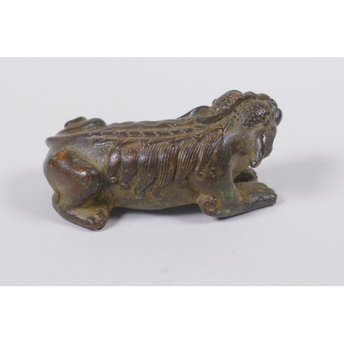 118 - A Japanese style bronze okimono in the form of a temple lion, 7cm long