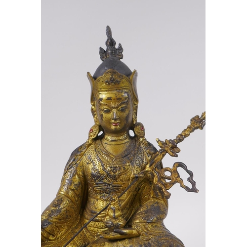 119 - A Tibetan gilt bronzed metal figure of Buddha seated on a lotus throne, impressed double vajra mark ... 