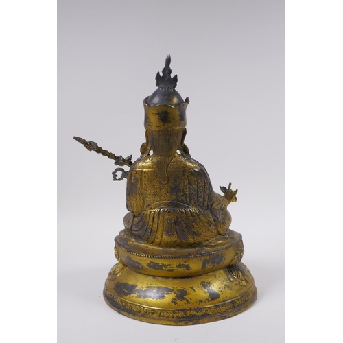 119 - A Tibetan gilt bronzed metal figure of Buddha seated on a lotus throne, impressed double vajra mark ... 