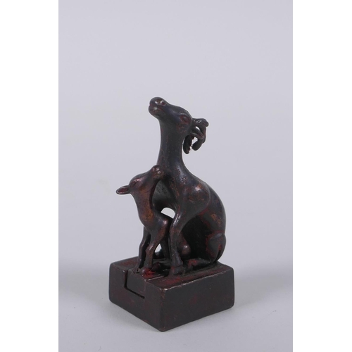 126 - A Chinese miniature bronze twin deer seal with the remnants of gilt patina, 5cm high