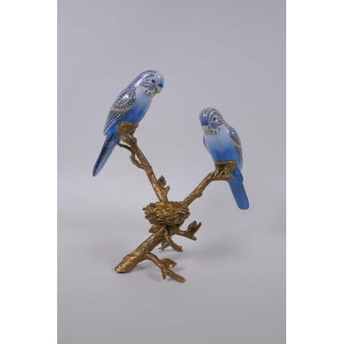 130 - A gilt metal tea light holder in the form of a tree branch with two polychrome porcelain birds perch... 