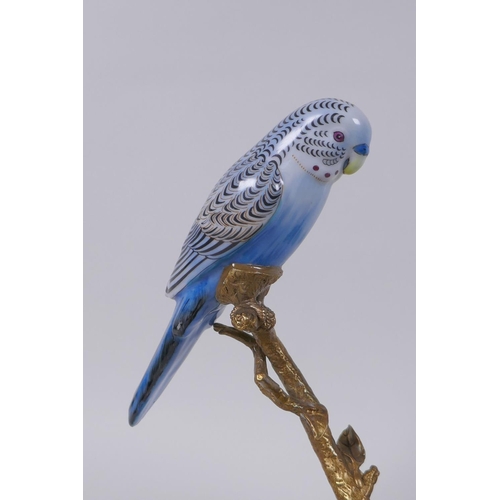 130 - A gilt metal tea light holder in the form of a tree branch with two polychrome porcelain birds perch... 