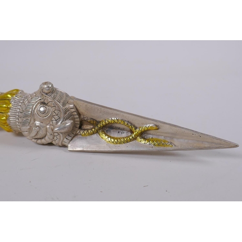 133 - A Tibetan white metal phurba, the handle decorated with the mask of a wrathful deity, 32cm long