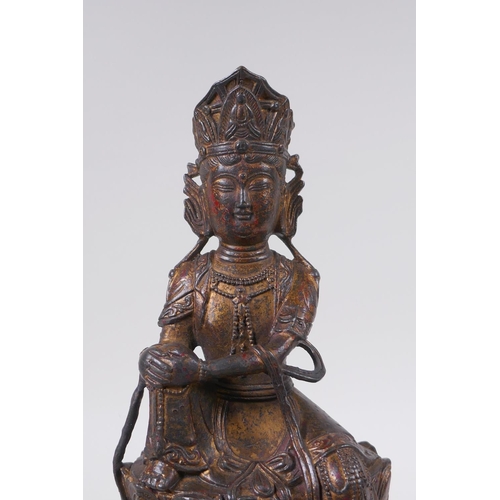 135 - A Sino Tibetan filled gilt bronze Buddha, seated on the back of a mythical creature, 32cm high