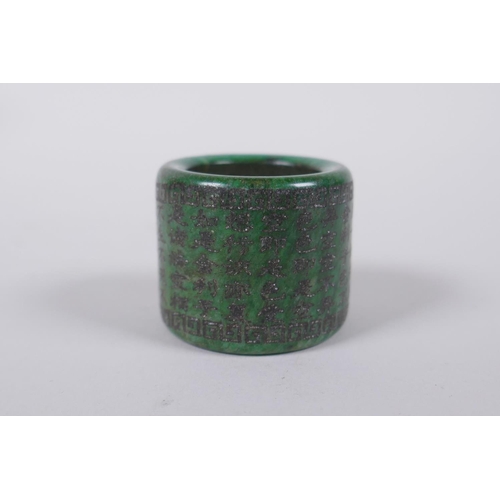 143 - A Chinese marbled green hardstone archers thumb ring, decorated with an allover character inscriptio... 