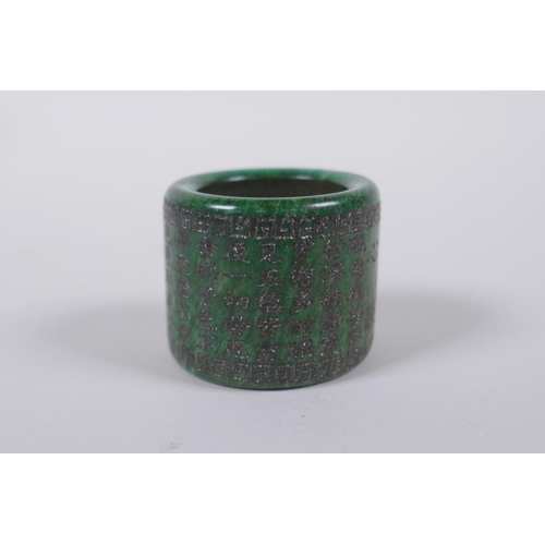 143 - A Chinese marbled green hardstone archers thumb ring, decorated with an allover character inscriptio... 